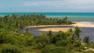 Vista panorâmica de Caraíva, Bahia, mostrando a vila entre o mar e o rio Caraíva — fotografia de Marcelino Dias.
